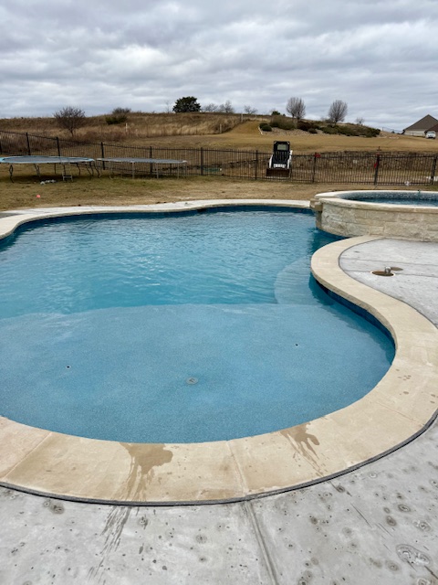 Inground pool with sun shelf and raised stone spa